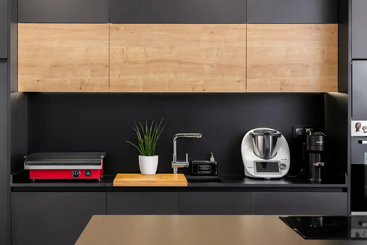 Cocina moderna con una plancha Crisinox roja integrada junto a otros electrodomésticos