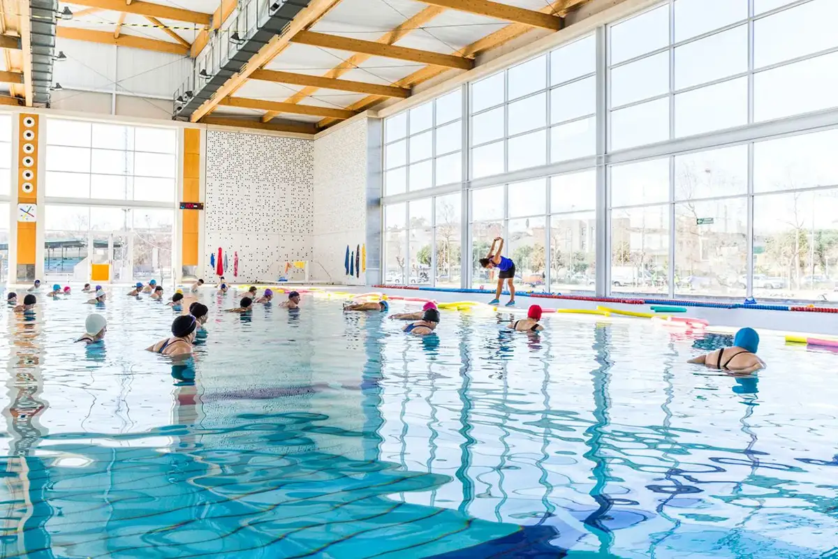 Fotografía de grupo de usuarios en piscina climatizada siguiendo a la monitora