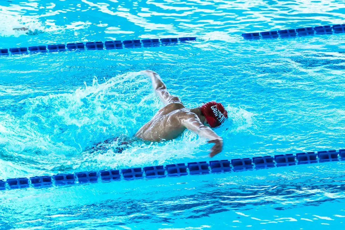 Fotografía de nadador realizando estilo mariposa en piscina interior