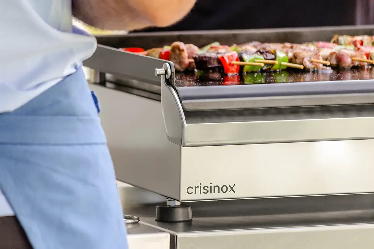 Fotografía de detalle de comida en plancha crisinox en exteriores