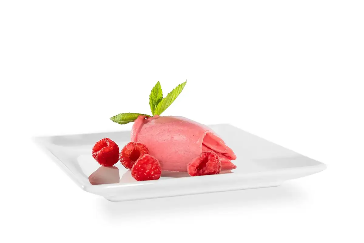 Fotografía de helado de fresa acompañado de frutos del bosque
