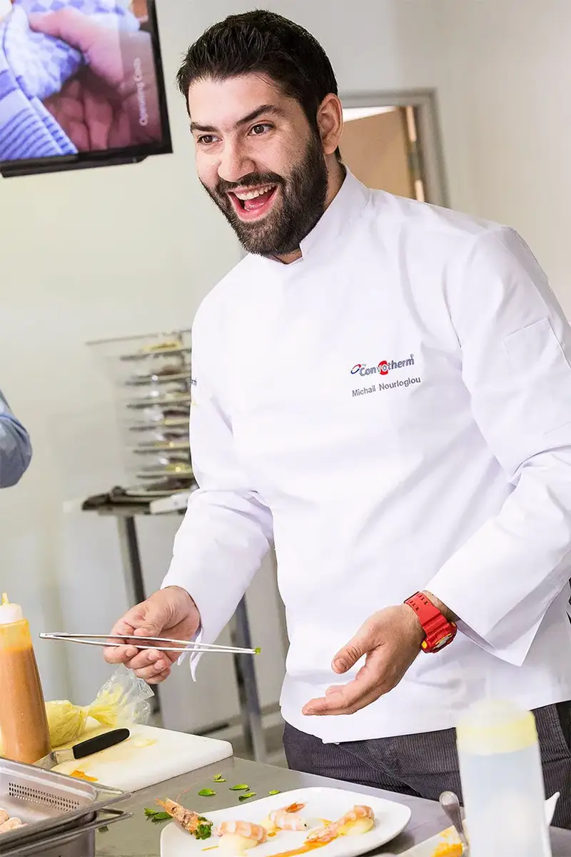 Chef en acción durante una sesión fotográfica en cocina profesional