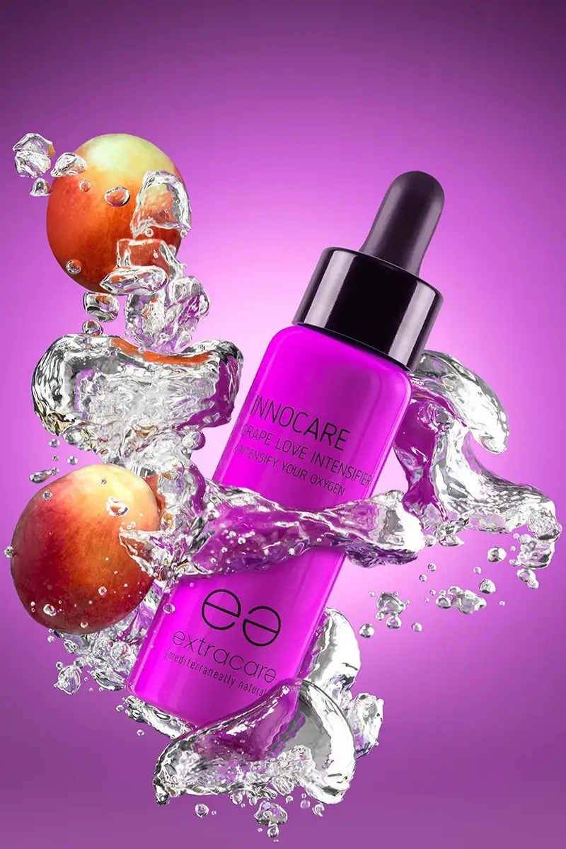 Fotografía creativa de cosmético morado flotando entre salpicaduras de agua